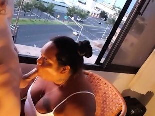 Bbw milf blowing cock in front of a window